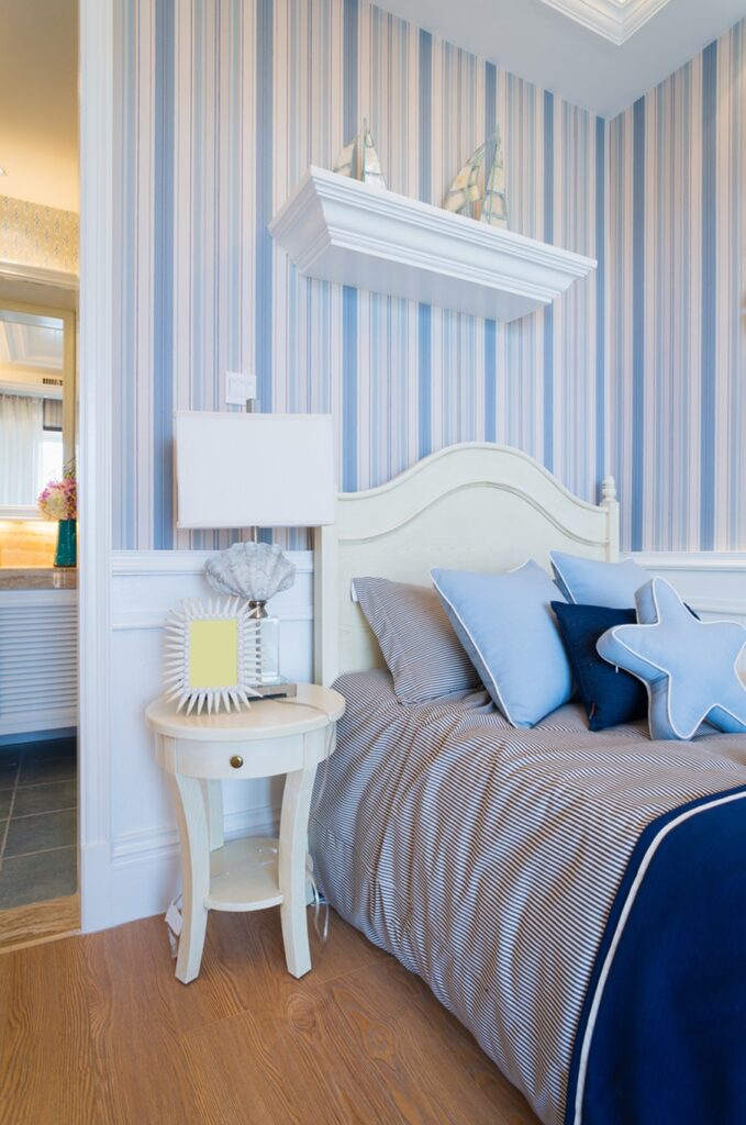 Blue watercolor paint on the wall in modern bedroom interior with a double bed and grey curtain