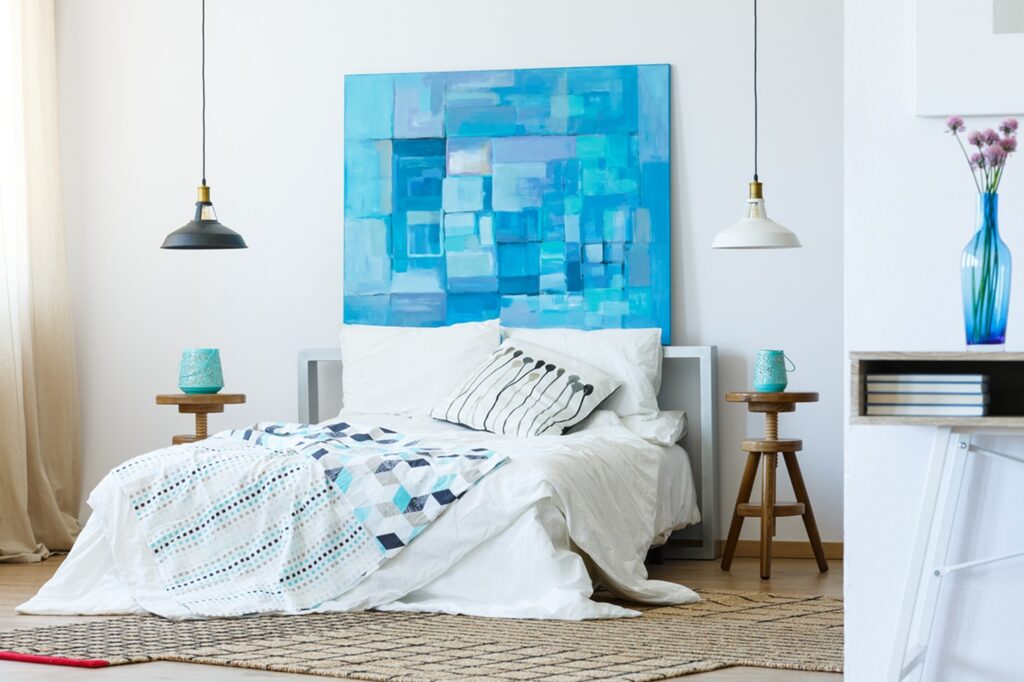 Natural and modern bedroom with blue painting on the wall